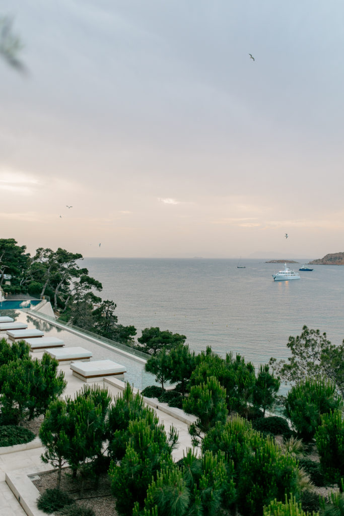 Drone view of a luxury seaside wedding venue in Greece showing dining area, dancing floor, and waterfront lounge deck.