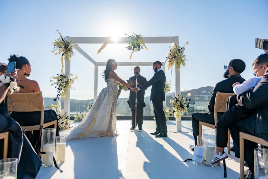 White minimalist wedding arch with black-and-white florals overlooking the Aegean Sea at a luxury Mykonos hotel.