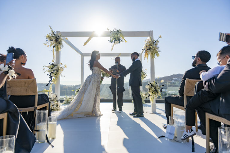 White minimalist wedding arch with black-and-white florals overlooking the Aegean Sea at a luxury Mykonos hotel.