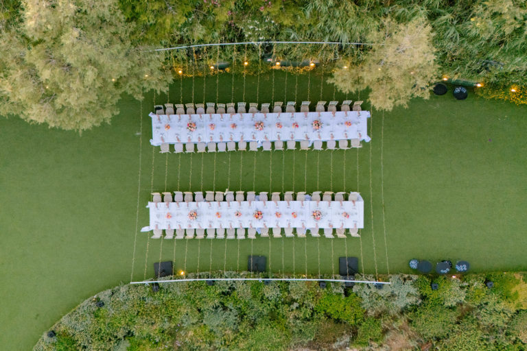 Vibrant long table decorated with pink flowers and elegant place settings at a luxury Athens Riviera wedding.